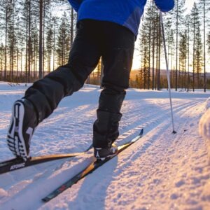 Hiihtoladut ja auringonlasku metsäisen maiseman keskellä, lähikuva jaloista
